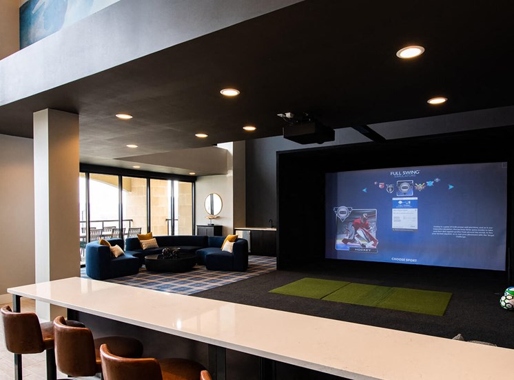 indoor movie theater screen with couches and barstools around a counter
